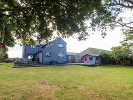 A house and shed in a garden with grass at Tyn Rallt Newborough