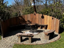 A garden seating area with a fire pit and wooden benches at Glas y Dorlan near Newport, Pembrokeshire