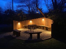 A garden with a firepit and wooden seating at Glas y Dorlan Nevern near Newport, Pembrokeshire