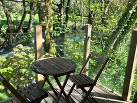 A table and chairs on an outdoor deck overlooking a stream at Glas y Dorlan Nevern near Newport, Pembrokeshire