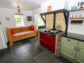 A kitchen with a red stove and a wooden bench at Glas y Dorlan near Newport, Pembrokeshire