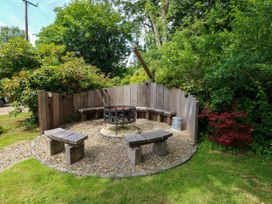 An outdoor area with a fire pit and wooden seating at Glas y Dorlan, Nevern near Newport, Pembrokeshire