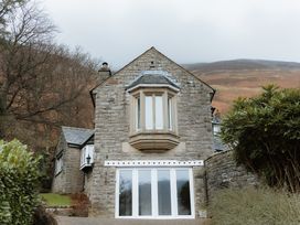A house with stone exterior and multiple windows at Grey Walls in Glenridding