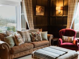 A living room with a sofa and armchair at Grey Walls in Glenridding