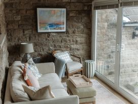 A conservatory with a sofa and a lamp at Grey Walls in Glenridding