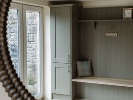 A hallway with a cabinet and shelf at Grey Walls in Glenridding