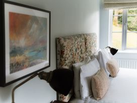 A bedroom with a floral headboard and artwork at Grey Walls in Glenridding