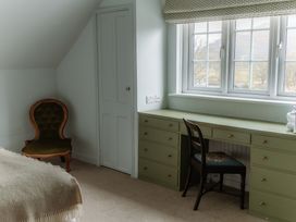 A bedroom with a desk and an armchair at Grey Walls in Glenridding