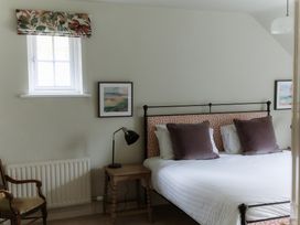 A bedroom with a bed, bedside table, and a window at Grey Walls in Glenridding