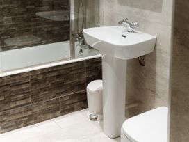 A bathroom with a sink, toilet, and bathtub at Grey Walls in Glenridding