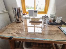 A table with a kettle glass jars spoons a radio and a window at Bryn Canaid in Uwchmynydd near Aberdaron