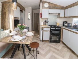 A kitchen with a dining table set with bowls and glasses and a stove with cooking utensils at Bay View Hillway near Bembridge