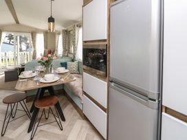 A kitchen and dining area with a table set for four and a sofa seating at Bay View in Hillway near Bembridge