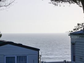 A sea view between two houses with trees at Bay View in Hillway near Bembridge