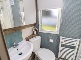 A bathroom with a sink toilet window and towel radiator at Bay View in Hillway near Bembridge