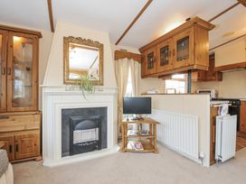 A living room with a fireplace and television at Little Malory St Giles-On-The-Heath