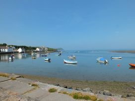 A harbor with boats on the water and houses along the shore at Glanduad Fawr in Newport Pembrokeshire