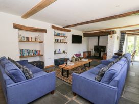 A living room with blue sofas wooden coffee table bookshelves and a fireplace at Glanduad Fawr in Newport Pembrokeshire