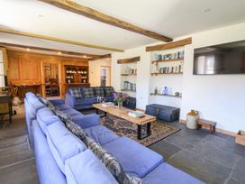 A living room with blue sofas a wooden coffee table and shelves with books at Glanduad Fawr in Newport Pembrokeshire