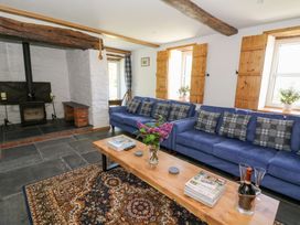 A living room with two blue sofas and a wooden coffee table near a fireplace at Glanduad Fawr in Newport Pembrokeshire