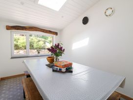 A dining area with a table covered by a patterned cloth with flowers and puzzle boxes on it at Glanduad Fawr in Newport Pembrokeshire