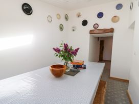 A dining room with a table covered by a cloth and decorated with flowers and board games at Glanduad Fawr in Newport Pembrokeshire