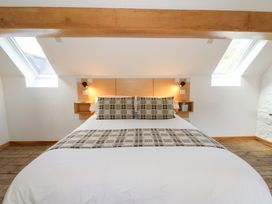 A bedroom with a double bed two patterned pillows skylight windows and wooden floor at Glanduad Fawr in Newport Pembrokeshire