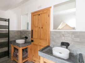 A bathroom with two sinks wooden door and black towel rack at Glanduad Fawr in Newport Pembrokeshire