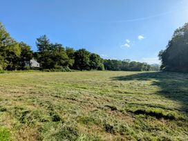 A field with a house and trees at Glanduad Fawr Newport, Pembrokeshire
