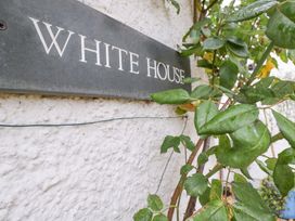 A sign reading 'WHITE HOUSE' on a wall with a plant at White House 