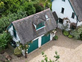 A garage with green doors and gravel driveway at White House in 