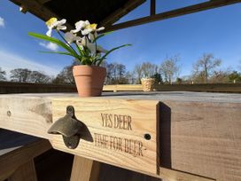 An outdoor seating area with a table and a flower pot at Yes Deer Ashbourne
