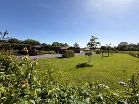 An outdoor space with grass and wooden structures at Yes Deer in Ashbourne
