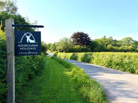 A sign for Ashbourne Holidays Luxury Glamping with a pathway at Ashbourne