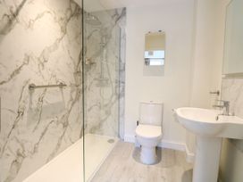A bathroom featuring a shower, toilet, sink, and a mirror at 1 Crowlands Cottages in Holt