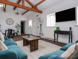 A living room with sofas, a table, and a television at Gannet in Flamborough