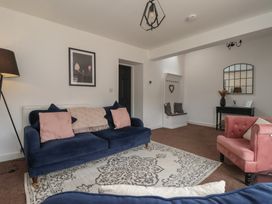 A living room with a blue sofa and a pink armchair at Razorbill in Flamborough