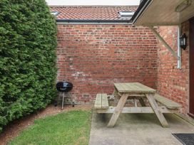 An outdoor area with a picnic table and grill at Razorbill in Flamborough