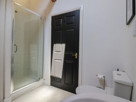 A bathroom with a shower enclosure a black door and a toilet at Guillemot in Flamborough