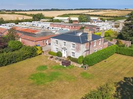 A house with a garden and caravan park in the background at Guillemot in Flamborough