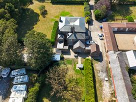 An outdoor view of a house with a driveway and adjacent trees at Guillemot in Flamborough
