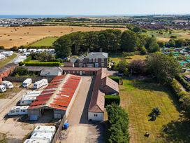 An outdoor view of a property with caravans and fields at Guillemot in Flamborough