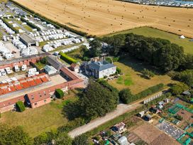 An outdoor view showing a field with caravans and several buildings at Guillemot in Flamborough