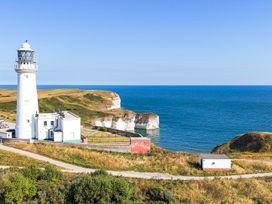 A lighthouse beside a cliff overlooking the sea at Guillemot in Flamborough