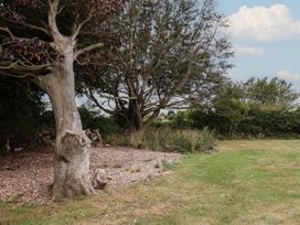 A garden area with trees and grass at Guillemot in Flamborough