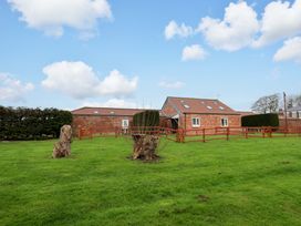 A house with a fence and tree stumps in an outdoor area at Guillemot in Flamborough