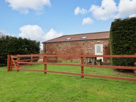 A garden area with a fenced enclosure and a door at Guillemot in Flamborough