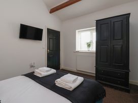 A bedroom with a bed and television at Puffin in Flamborough