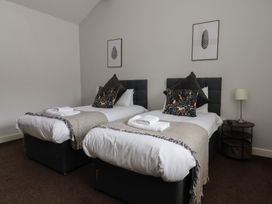 A bedroom with two single beds and a nightstand at Puffin in Flamborough