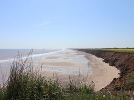 A view of a beach and cliff with grass in the foreground at Puffin in Flamborough